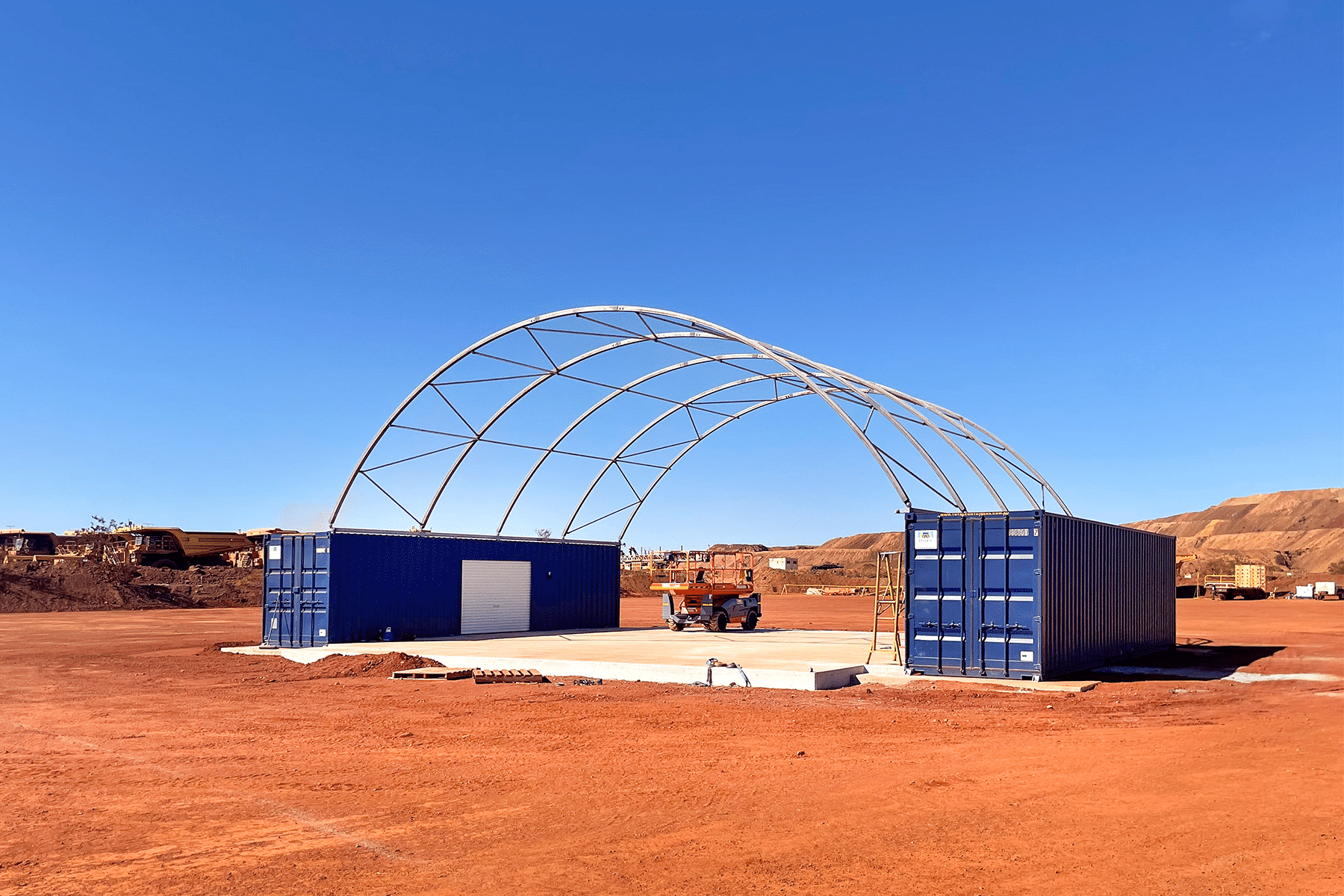 photo of a concrete slab and shipping containers with a dome structure on a pilbara site